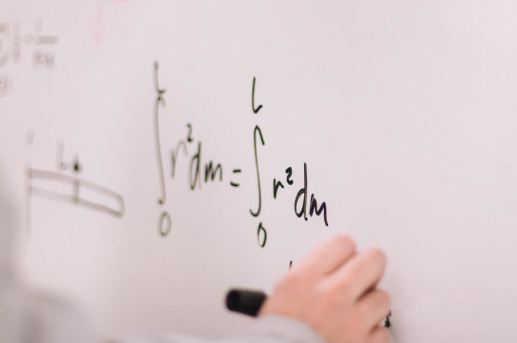 someone writing an Calculus problem on a white board