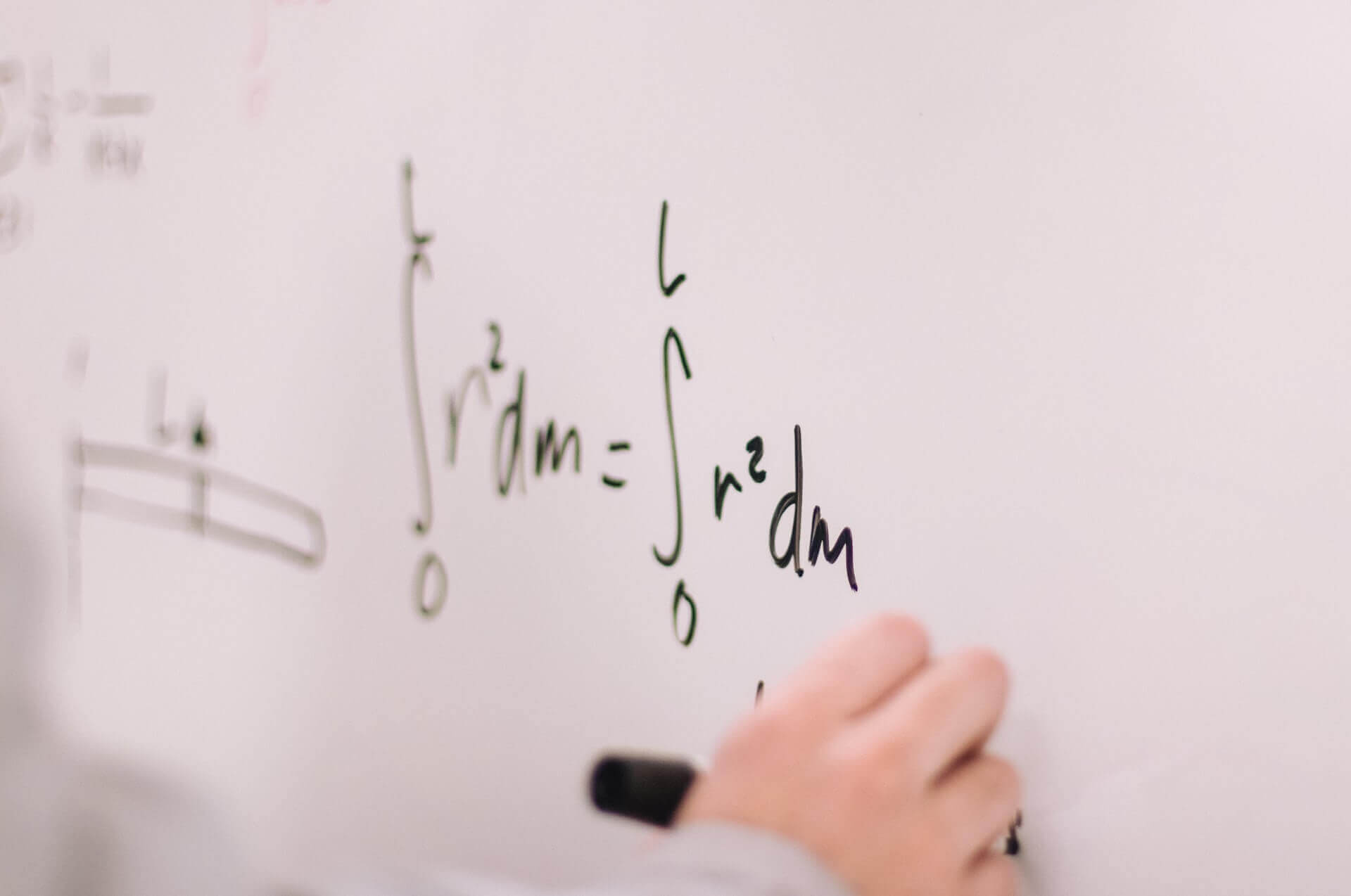 someone writing an Calculus problem on a white board