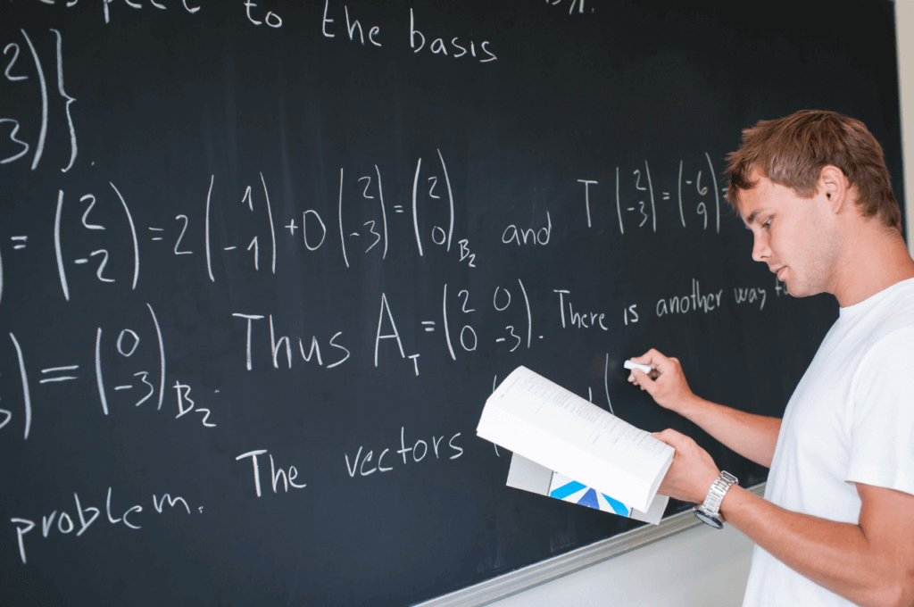 The image shows a student holding a math book in one hand while solving a Calculus problem on the dry erase board.